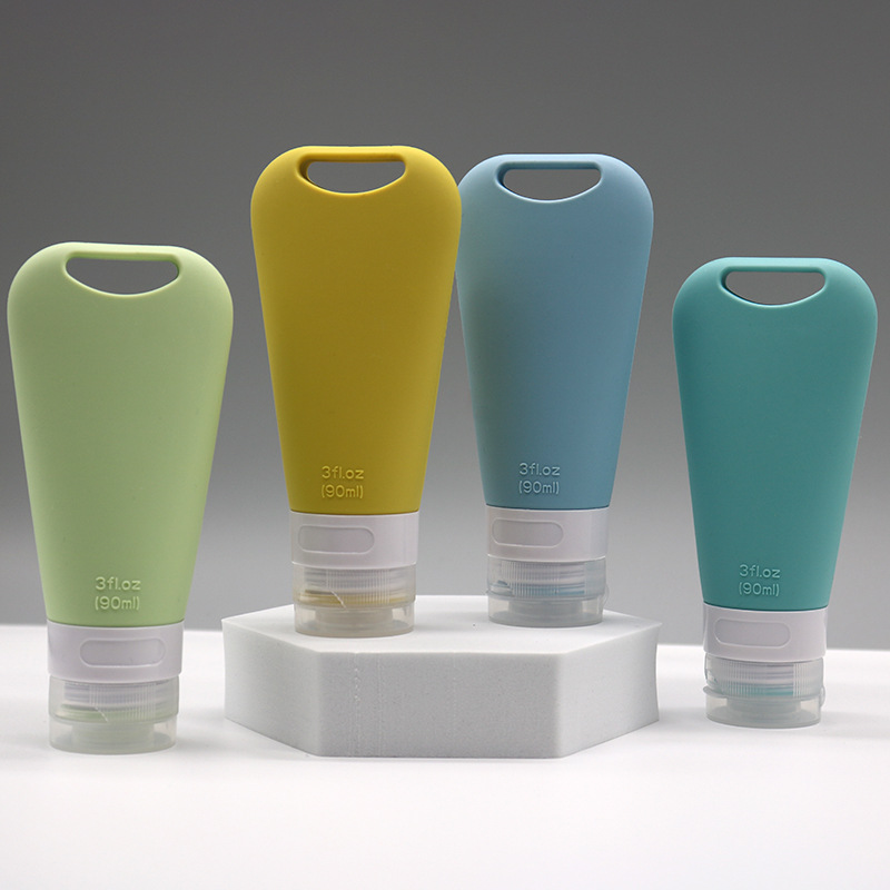 Portable silicone travel bottles with integrated carry handles in various sizes for leak-proof toiletry and lotion storage.