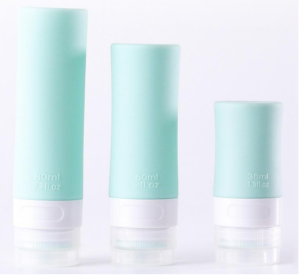 Complete travel toiletry kit featuring squeeze silicone bottles, spray dispensers, cream jars, and cleaning tools in a transparent carry bag.