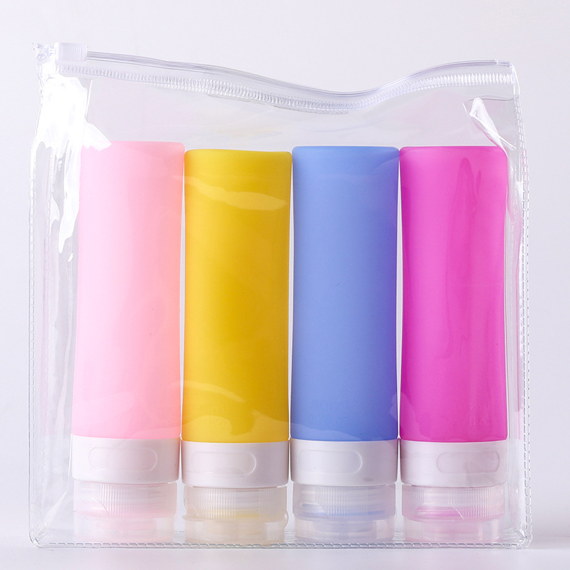 Complete travel toiletry kit featuring squeeze silicone bottles, spray dispensers, cream jars, and cleaning tools in a transparent carry bag.