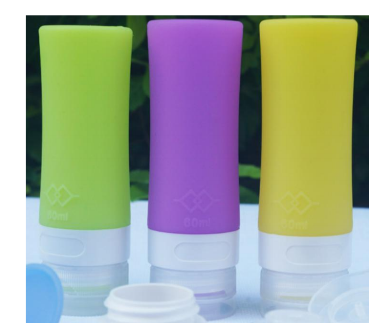 Complete travel toiletry kit featuring squeeze silicone bottles, spray dispensers, cream jars, and cleaning tools in a transparent carry bag.