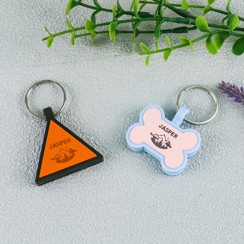 Customized pet ID tags in various geometric shapes like bone, triangle, and hexagon with engraved names for dog and cat safety.